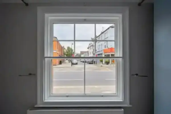 A quiet London street viewed through a perfectly installed sash window.