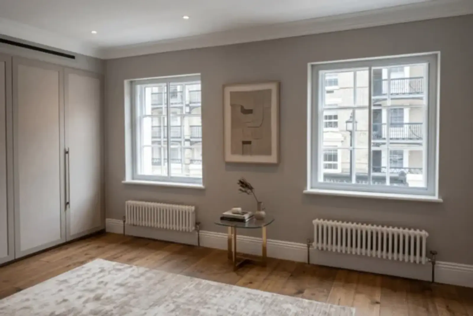 Calm period-style room with two secondary glazed windows, radiators and timber floor