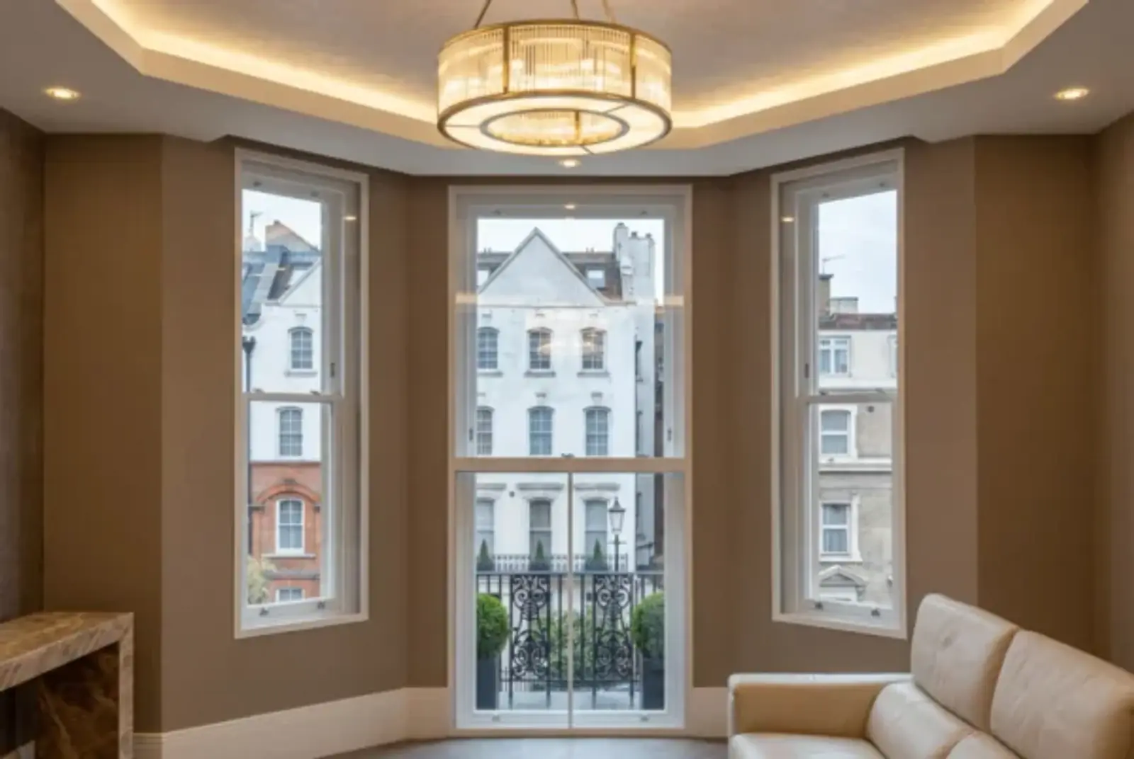 Warm sitting room with three secondary glazed windows overlooking London terraces