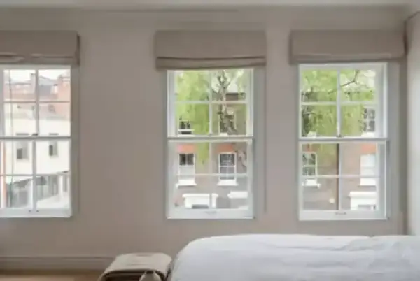 A peaceful bedroom with sash windows showing how secondary glazing creates a quiet, warm sanctuary